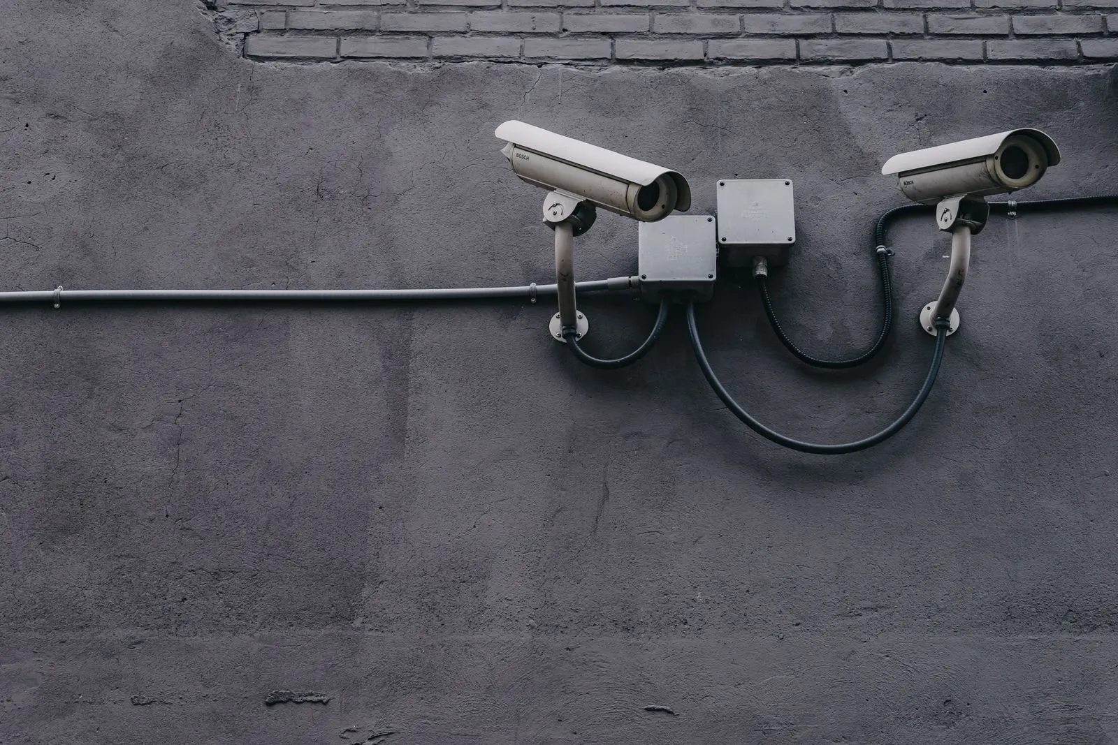 Two professional CCTV cameras mounted on a commercial building wall