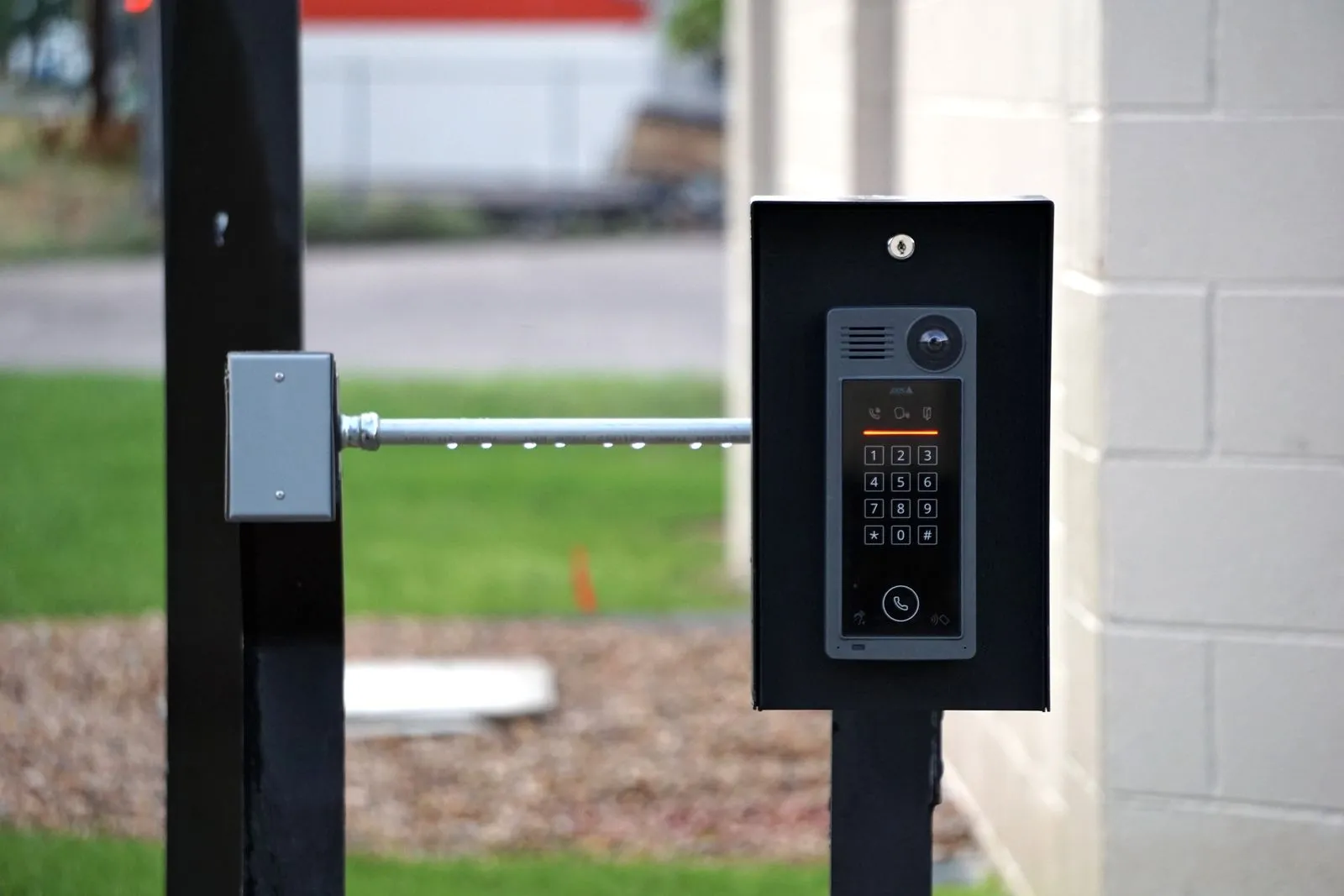 Modern video intercom and keypad entry panel mounted at a site gate