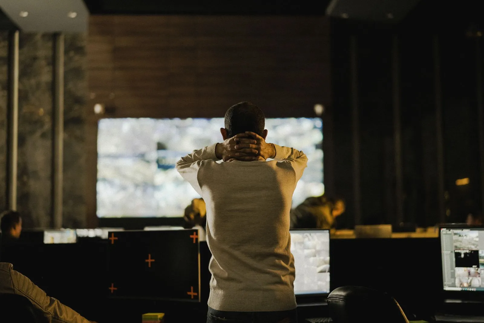 Operator watching a wall of CCTV monitors in a security control room